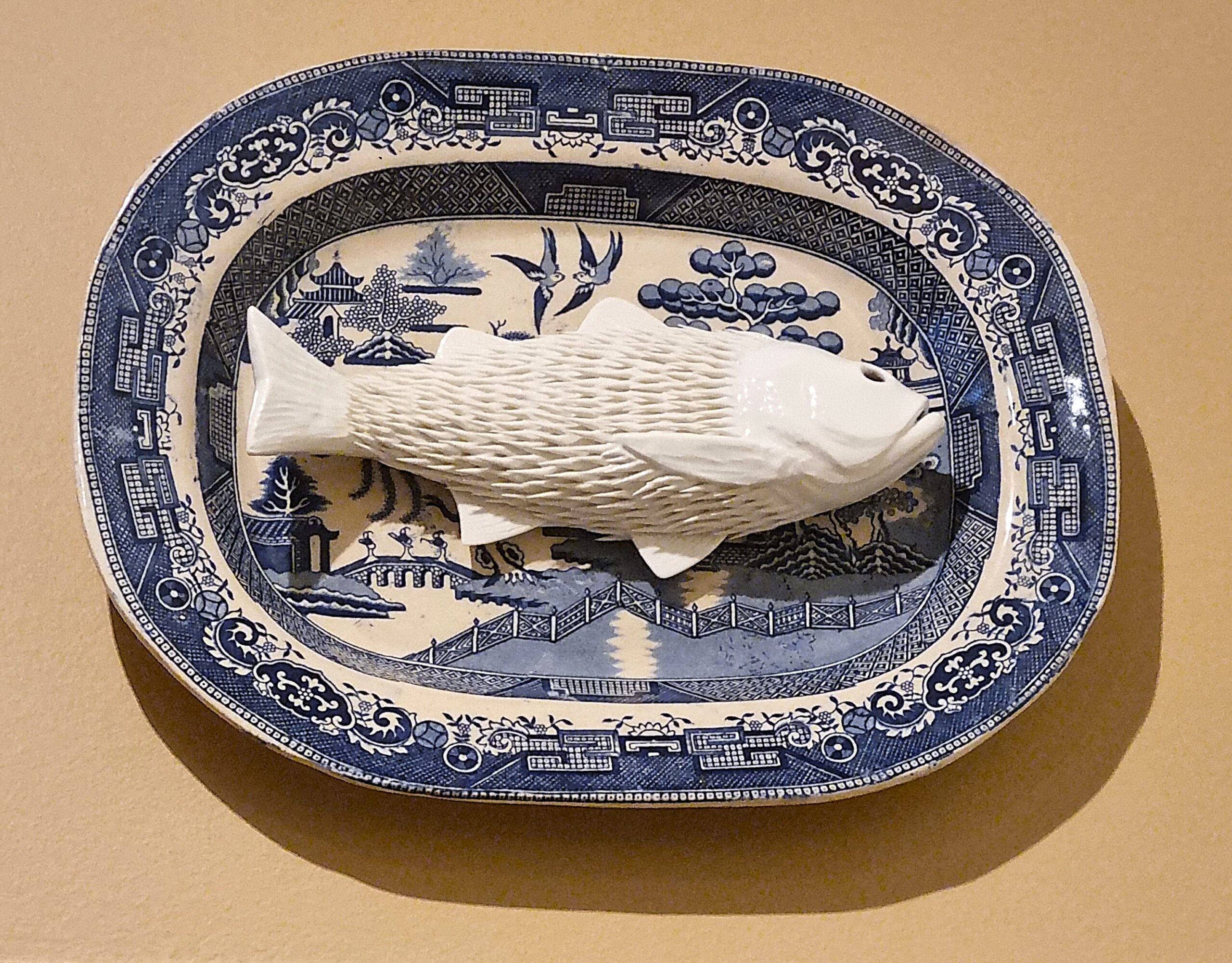 Ikuko Iwamoto, “I ate lots of plastics, and now I am your dinner. Enjoy!” Seabass, 2025, porcelain and found man made object, 34x40x8cm represented by Cavaliero Finn