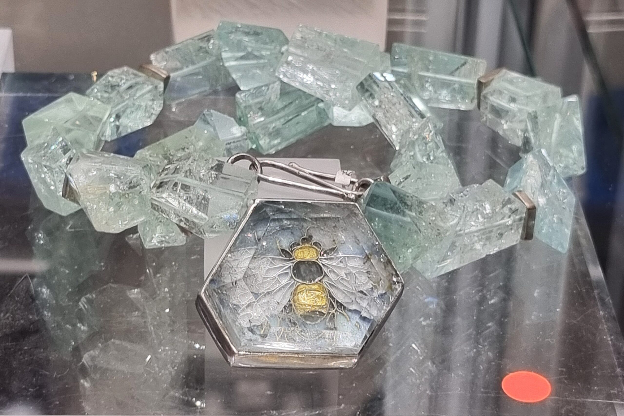 Unique necklace by Alexandra Raphael featuring a silver and gold bee with aquamarine set on top and aquamarine beads